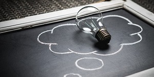 Lightbulb Placed Inside Outline of a Cloud Drawn on a Blackboard